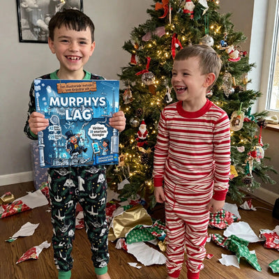 Julmorgon, pojke håller upp Murphys lag för barn vid granen